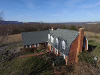 Rural, brick home with a gray shingle roof