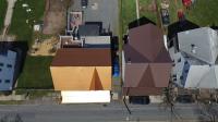 Top view of several homes: one with an orange metal roof and another with a brown metal roof